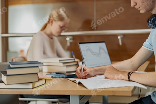 Preview: Students sit in the library and take notes while preparing for the exam