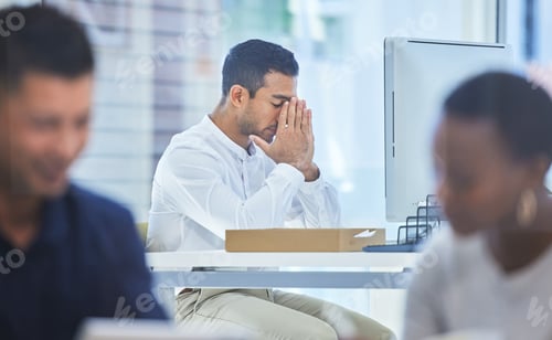 Preview: Defocused shot of a businessman looking stressed while sitting at his desk