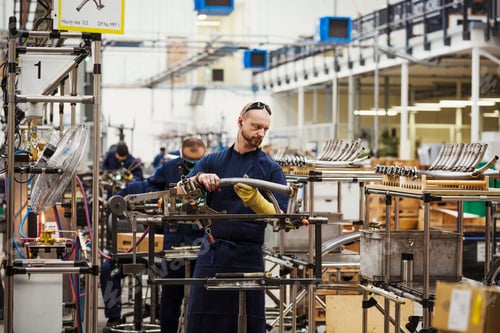 Preview: A man wearing one protective glove with sunglasses on his head, skilled factory worker working on