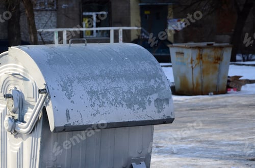 Preview: A silver garbage container stands near residential buildings in winter