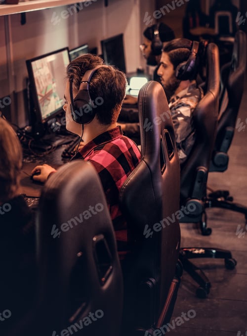 Preview: Team of teenage gamers plays in a multiplayer video game on pc in a gaming club.