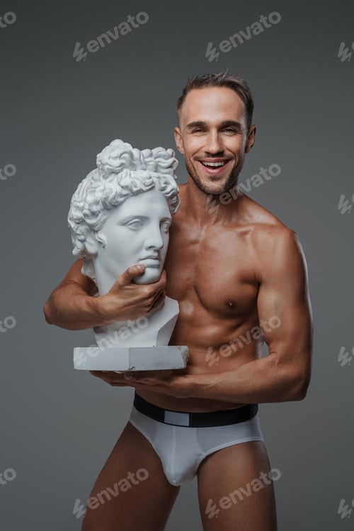 Preview: An attractive male model, dressed only in underwear on a gray backdrop