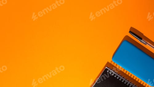 Preview: Top view of a smartphone and a notepad with a pen on an orange background