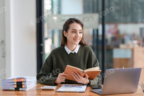 Preview: Beautiful Asian businesswoman working on her laptop and having fun at work and read