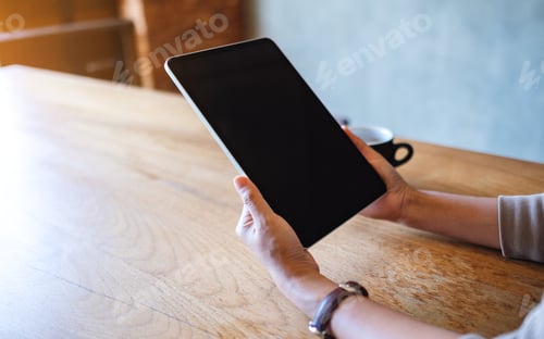 Preview: Closeup image of a woman holding and using digital tablet