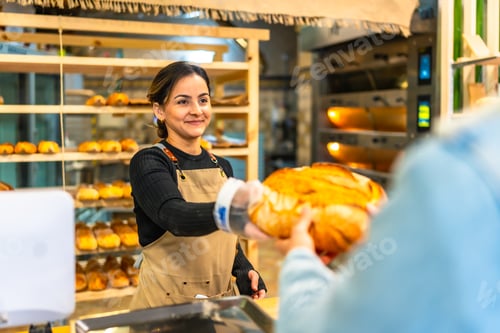 Preview: Woman selling bread to a client in an artisan bakery