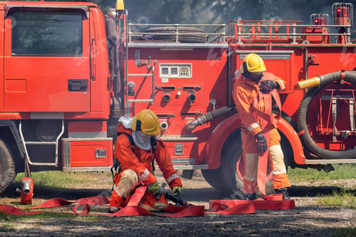 Preview: Firefighter wearing fire protection suite and oxygen tank exercise roll hose connect with fire truck
