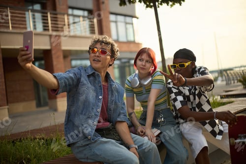 Preview: Group of Diverse Teens Taking Selfie Outdoors during Sunset