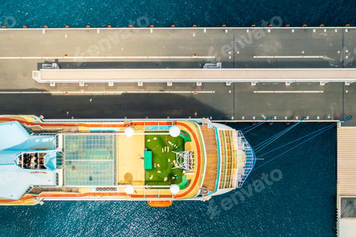 Preview: Top view of luxury cruise ship with golf field on the roof at anchor moored in marina on the blue