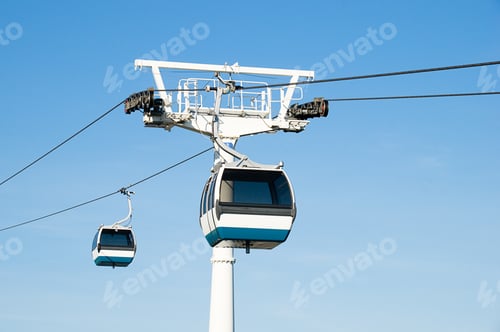 Preview: Closeup shot of a cable cars on a ropeway with a blue sky background