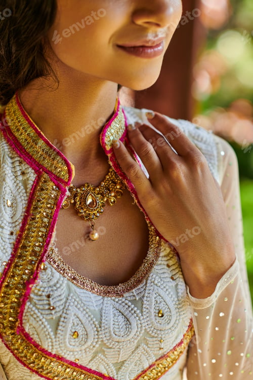Preview: cropped view of smiling indian woman in traditional attire and jewelry necklace posing outdoors