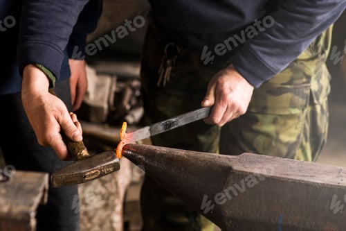 Preview: Closeup shot of a blacksmith forging a hinge on an anvil