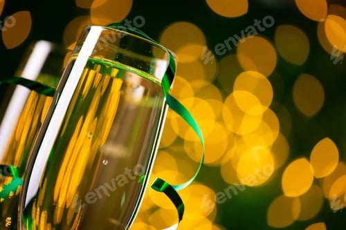 Preview: Two glasses of champagne against bokeh lights background. New Year celebration concept