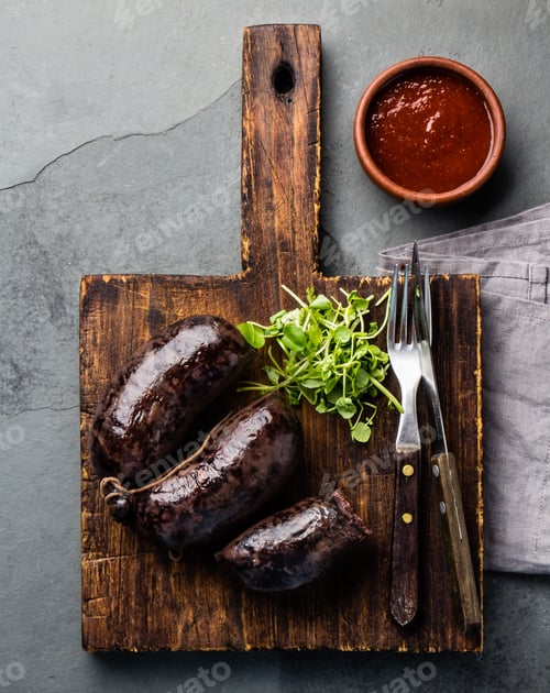Preview: Bloody sausages - prieta on wooden board with chili sauce, top view