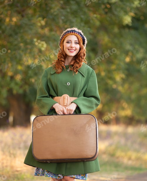 Preview: Redhead girl with suitcase at tree's alley.