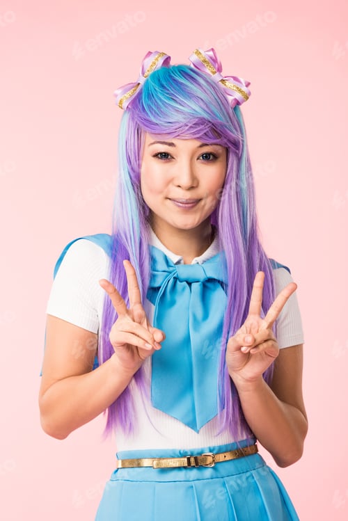 Preview: Smiling anime girl in purple wig showing peace signs isolated on pink