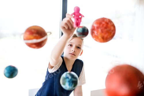 Preview: A small boy with model of solar system indoors