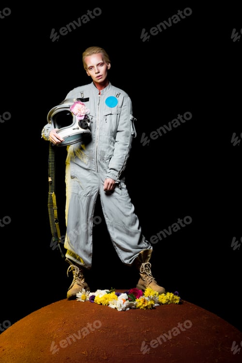 Preview: beautiful female cosmonaut posing in spacesuit with flowers and helmet on mars