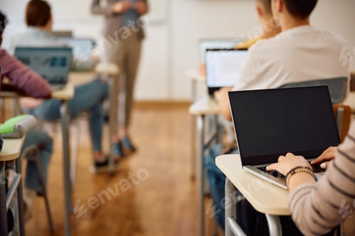 Preview: Close-up of high school student using laptop during computer class at school.