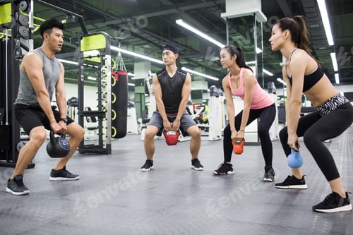 Preview: Young adult working with trainer at gym