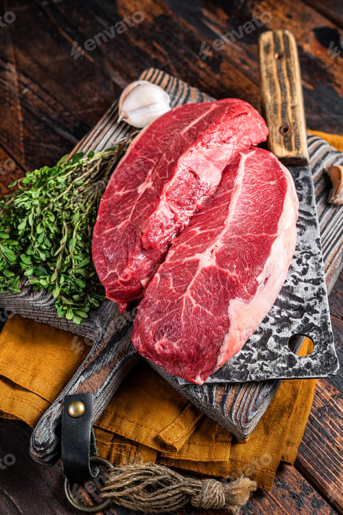 Vista previa: Dry aged Raw top blade beef meat steaks. Dark background. Top View