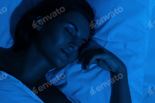 Preview: Young woman peacefully sleeping in the bed