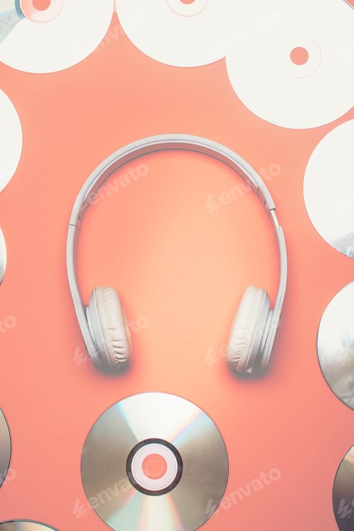 Preview: White wireless headphones with discs around with pink background.