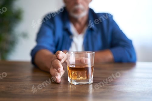 Preview: Senior caucasian man taking glass of wishy at home