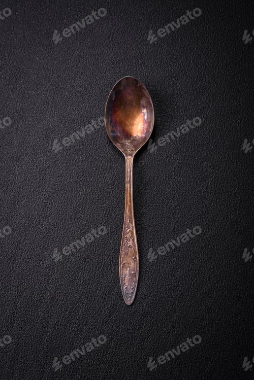 Preview: Empty metal spoon on dark textured concrete background