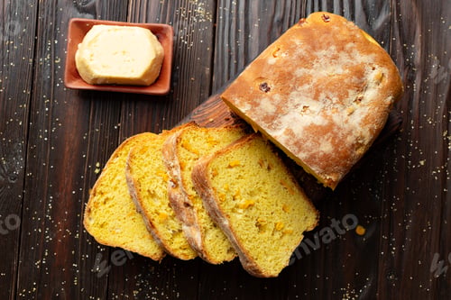 Preview: Flat lay view at homemade cornbread slices and butter on kitchen table