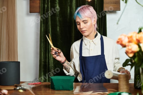 Preview: Creative florist arranging beautiful flowers in her charming flower shop