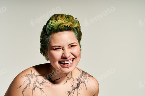 Preview: Vibrant woman showcases her unique style and confidence with artistic tattoos and lively expression