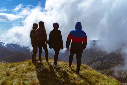 Preview: The four active people standing on the mountain with a beautiful view.