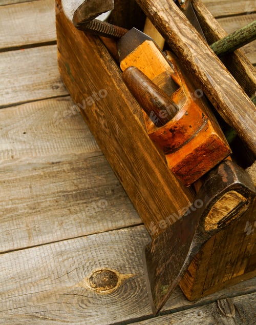 Preview: Old working tools in box on wooden background.