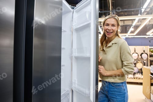 Preview: A Young Woman Joyfully Interacting with a Contemporary Refrigerator in a Retail Store Setting