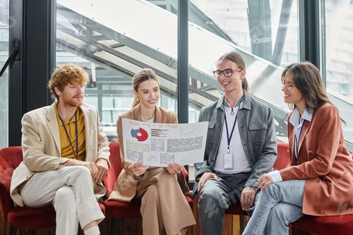Preview: creative team looking at their paperwork with chart while sitting on chairs, coworking concept