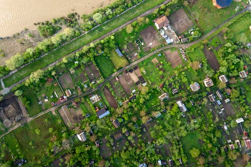 Preview: Aerial landscape view of village houses and distant green cultivated agricultural fields with