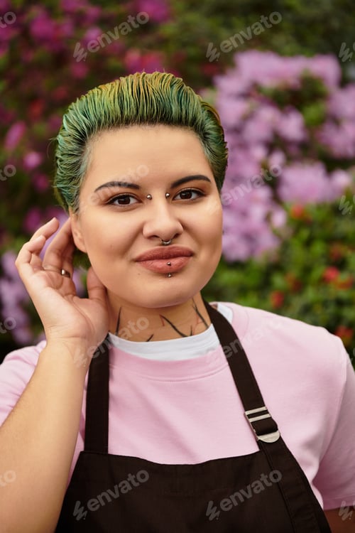 Preview: Young woman joyfully tending to plants in a vibrant greenhouse full of blooming flowers