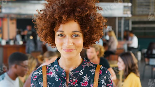 Preview: Close Up Portrait Of Female Server In Busy Bar Restaurant Smiling At Camera
