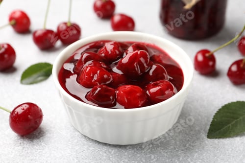Preview: Tasty cherry jam and fresh fruits on light table, closeup