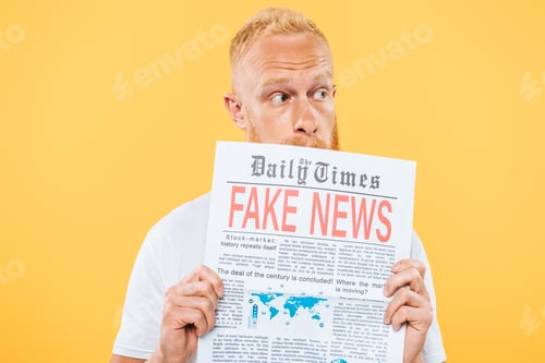 Preview: worried man holding newspaper with fake news, isolated on yellow