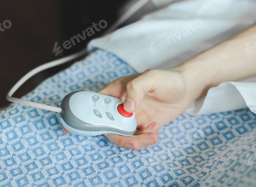 Preview: The hand of a young caucasian male patient lying in bed and holding a remote control in his hands