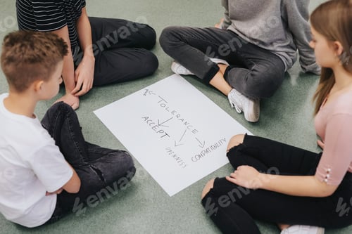 Preview: Group of teenagers sit in a circle on the floor and prepare a project together