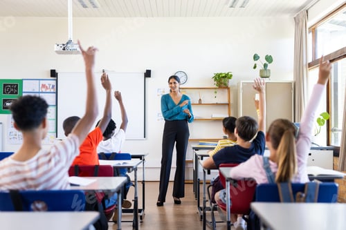 Preview: Indian female teacher in classroom, students raising hands to answer question in school