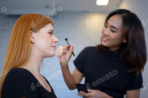 Preview: Young woman is make up her face at beauty salon.