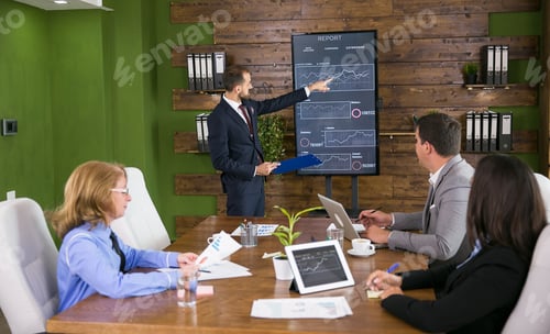 Preview: Businessman in suit having a presentation with charts on tv screen