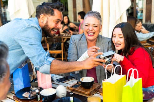 Preview: Friends sharing laughter and memories with vintage camera in murcia