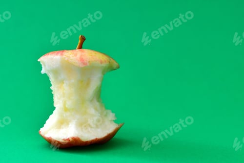 Preview: A red and yellow gala apple core on a green background