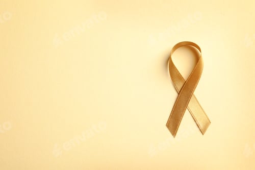Preview: Gold ribbon on color background, top view. Cancer awareness