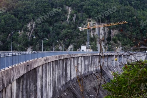 Preview: Construction crane working on a dam in a mountain forest